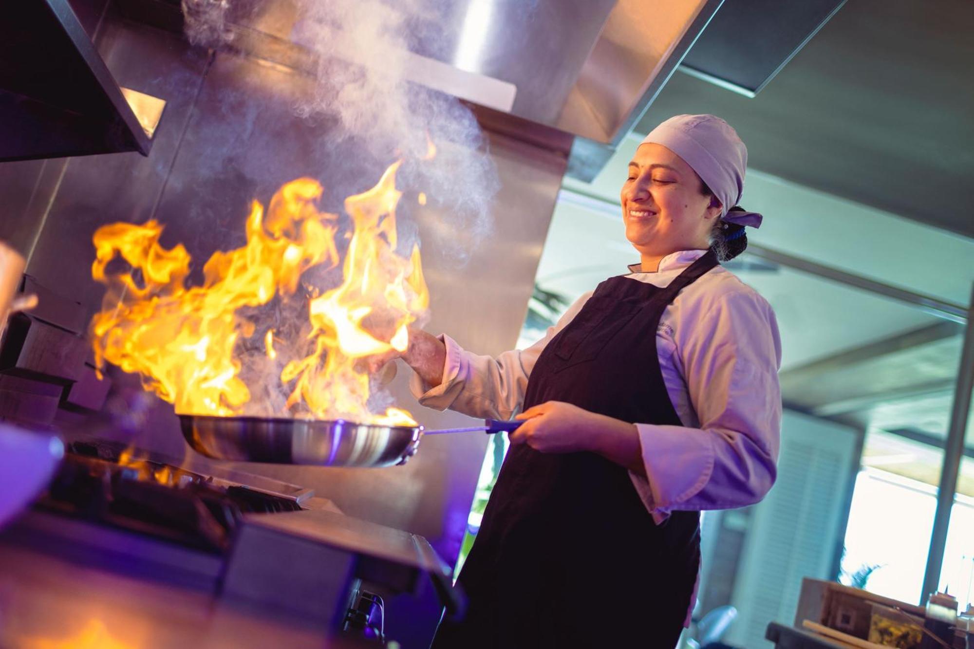 Santa Marta Marriott Resort Playa Dormida Exterior foto A chef cooking with a flaming skillet